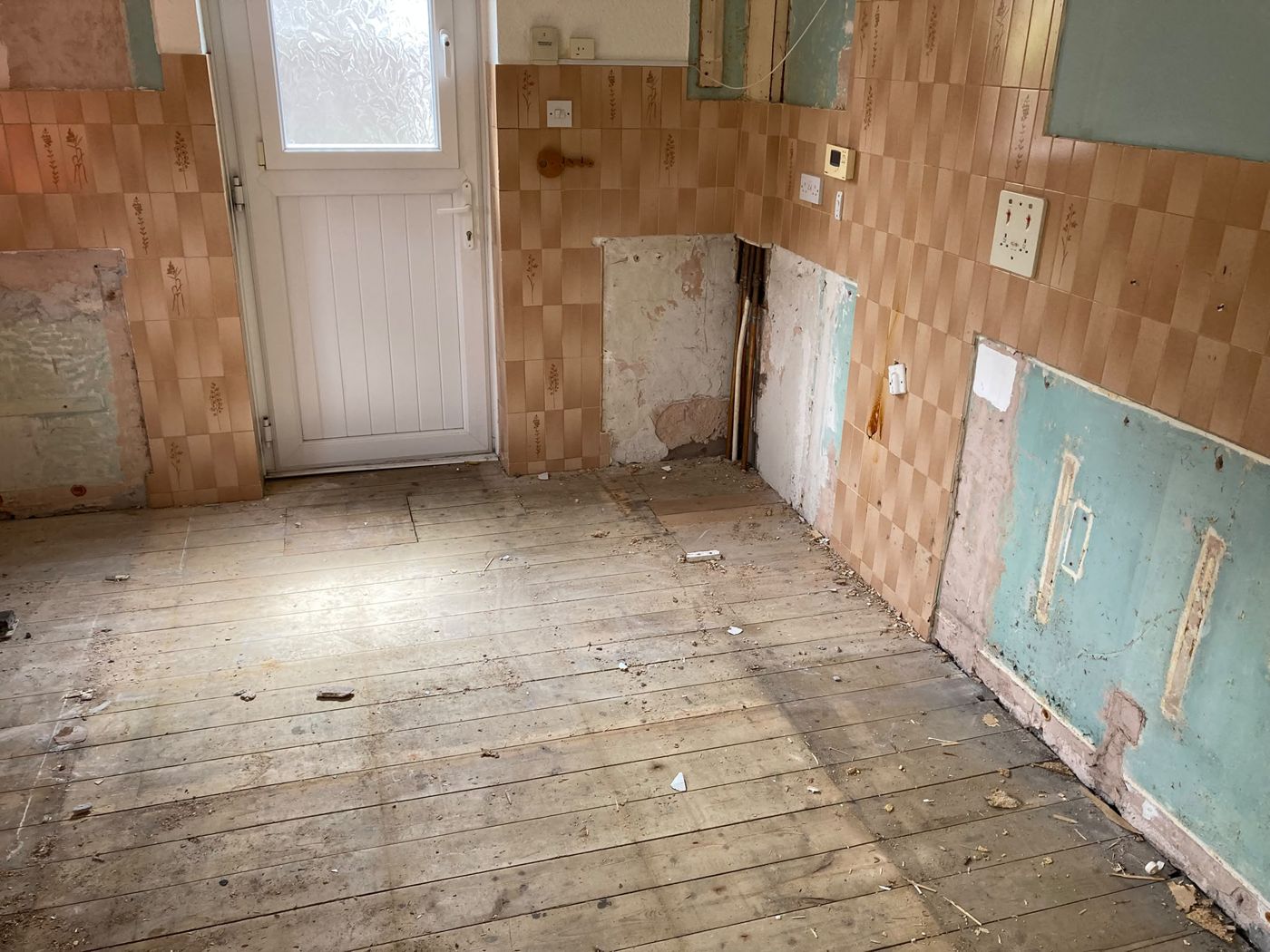 A kitchen fully cleared and stripped back after a house clearance